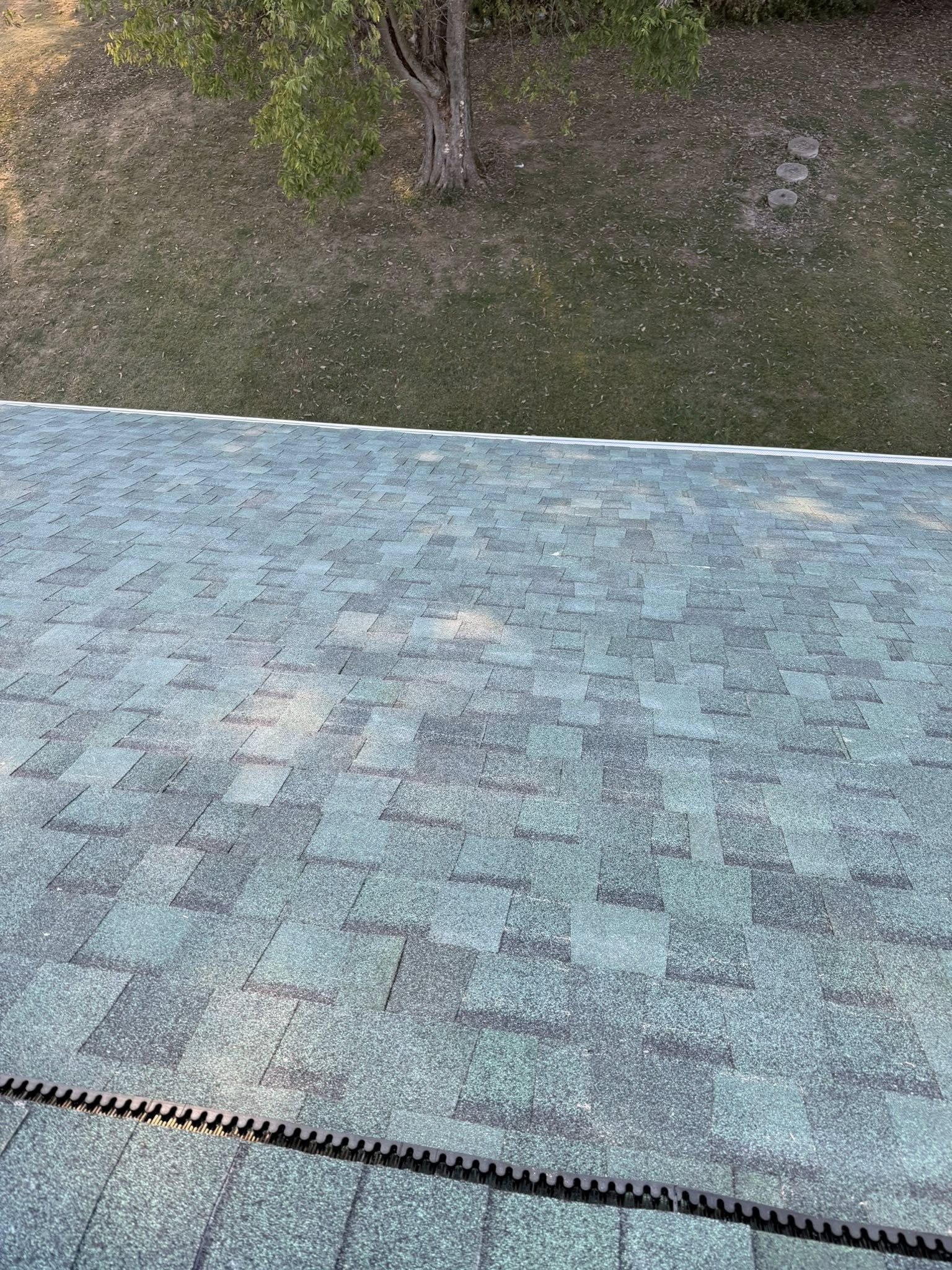 Completed residential roof replacement with new architectural shingles installed on a two-story home