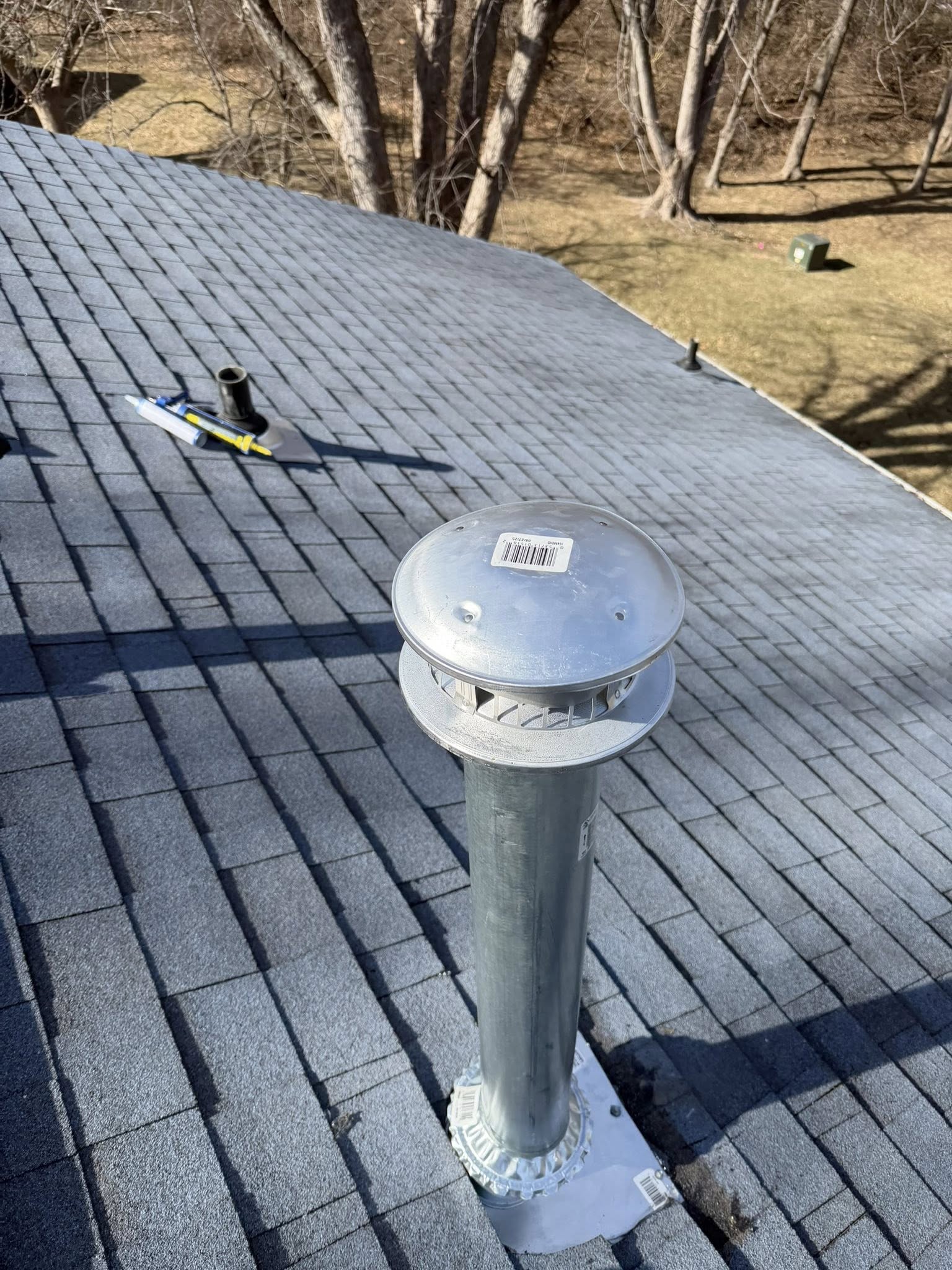 Professional roof inspection of residential asphalt shingle with vent pipe detail and barcode tag
